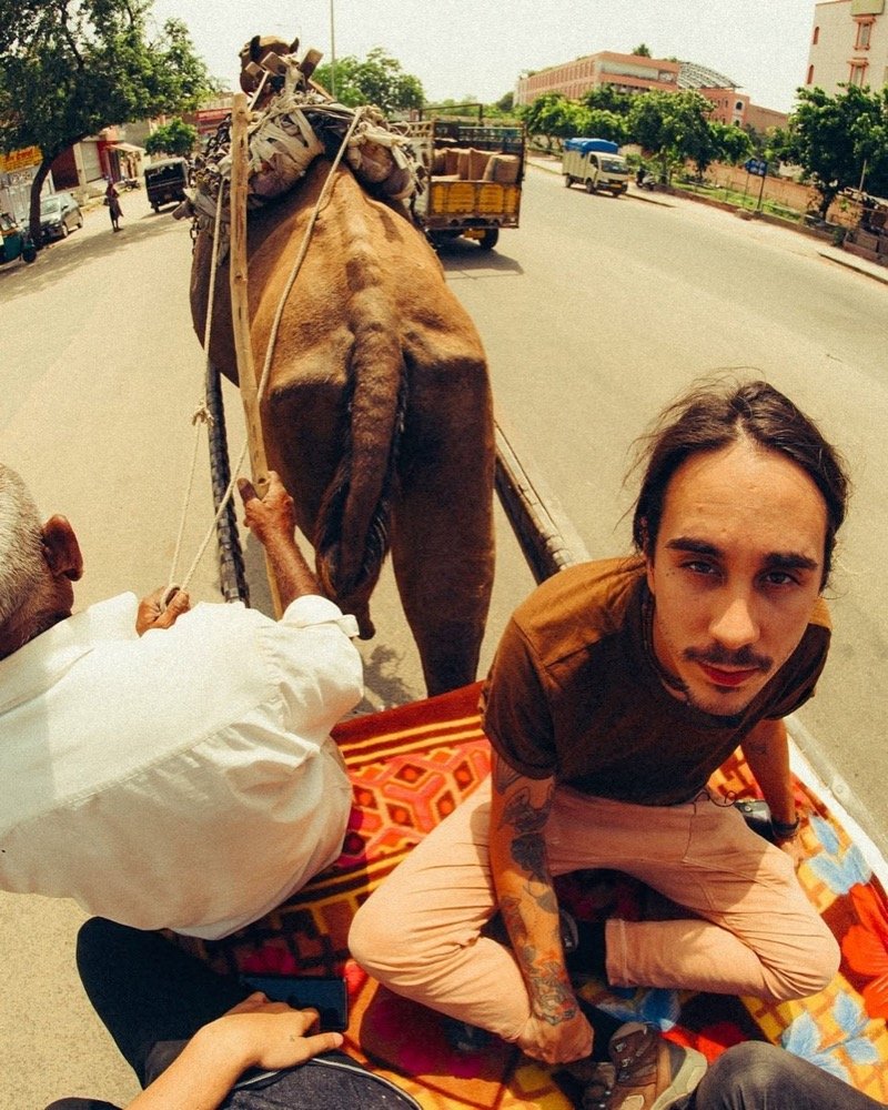 Dakota riding through India on a camel cart